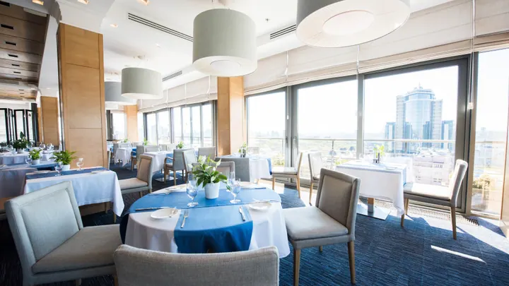 The dining room of a restaurant, laid and empty before service
